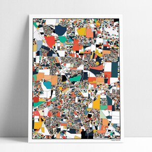 May include: A framed abstract map print with a white border. The map is composed of colorful geometric shapes in shades of red, orange, yellow, blue, and green. The print has a modern, artistic style.