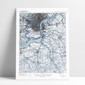 May include: A vintage map of Philadelphia, Pennsylvania, with blue lines highlighting the Delaware River and its tributaries. The map shows the city's streets, parks, and other features.