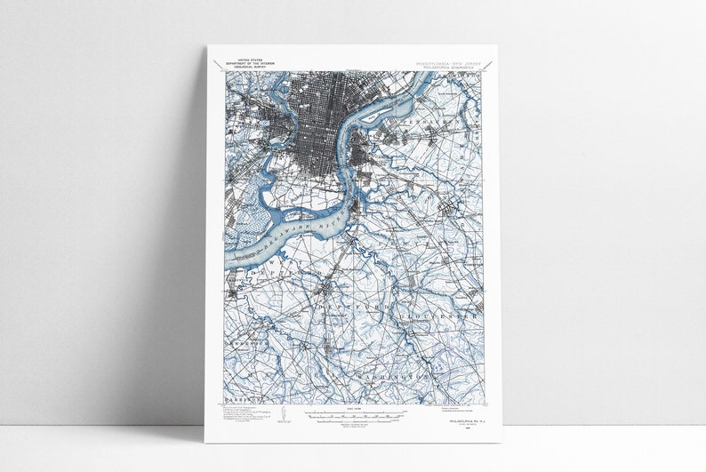 May include: A vintage map of Philadelphia, Pennsylvania, with blue lines highlighting the Delaware River and its tributaries. The map shows the city's streets, parks, and other features.