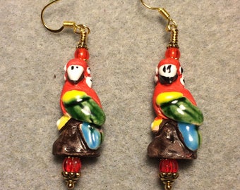 Large red, green, yellow and blue ceramic parrot bead earrings adorned with red Czech glass beads.