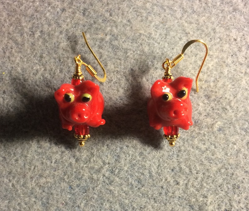 Small red lampwork pig bead earrings adorned with red Czech glass beads. Red lamp work pig earrings