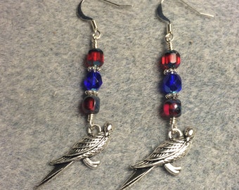 Silver bird (macaw) charm earrings adorned with red and blue Czech glass beads.