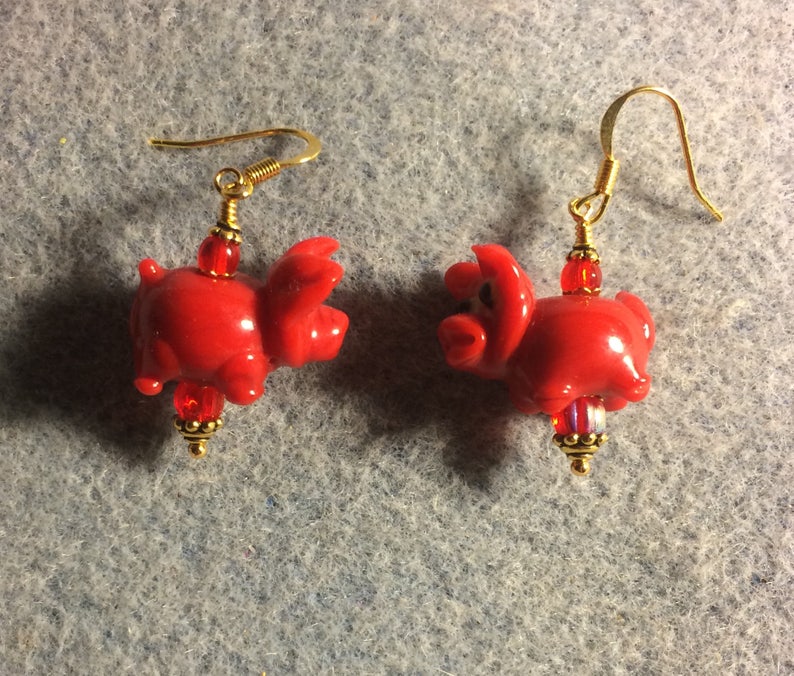 Small red lampwork pig bead earrings adorned with red Czech glass beads. Red lamp work pig earrings
