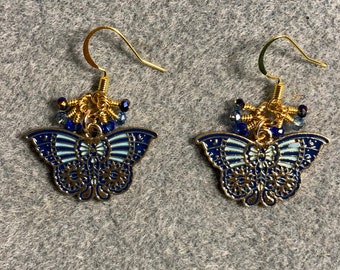 Dark blue and light blue enamel butterfly dangle earrings adorned with tiny dangling dark blue and light blue Chinese crystal beads.