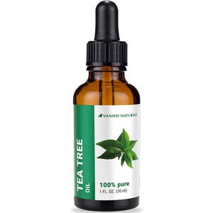 Könnte beinhalten: Eine braune Glasflasche Teebaumöl mit einer schwarzen Pipette. Das Etikett ist weiß und grün, mit dem Text "TEA TREE OIL" und "100% pure 30 ml". Der Markenname "VANDO NATURALS" ist ebenfalls sichtbar.