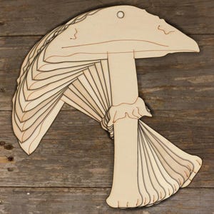 May include: A set of 10 unfinished wooden mushroom shapes, ideal for crafting and decorating. Each mushroom is approximately 10 cm tall and 7.5 cm wide.