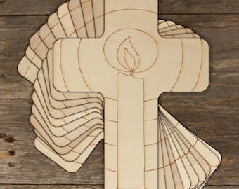 May include: A stack of unfinished wooden cross shapes with a candle design. The crosses are ready to be painted or stained.