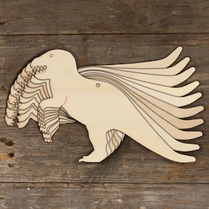 Puede incluir: Un recorte de dinosaurio de madera con un diseño en capas. El dinosaurio está mirando hacia la derecha y tiene una cola larga. El recorte está hecho de madera marrón claro y tiene un agujero en el centro.