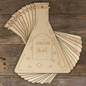 May include: A set of 15 unfinished wooden cutouts shaped like potion bottles with a label that reads "Goblins Snot".