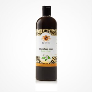 Può includere: Una bottiglia di vetro marrone di sapone nero al cumino nero con un'etichetta dorata. L'etichetta presenta un logo con un cerchio e una foglia, le parole "Gye Nyame", "Black Seed Soap", "Jasmine - Neroli", e il sito web "www.gyennyameholistics.com".