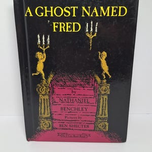 May include: A hardcover book titled "A Ghost Named Fred" with a black cover and yellow text. The cover features illustrations of candelabras and figures. The author is Nathaniel Benchley, with pictures by Ben Shecter. An "I Can Read Book".
