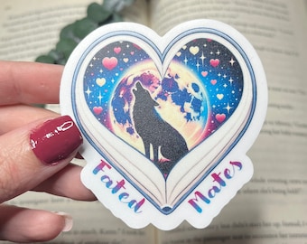 Fated Mates waterproof sticker. Features a wolf howling under a full moon and bright night sky, wrapped around a heart shaped book.
