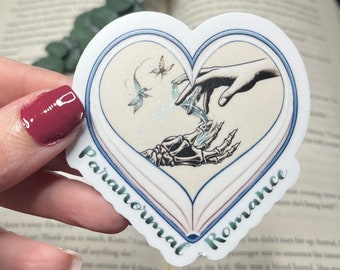 Magical Paranormal Romance Sticker. A book shaped heart surrounds two hands reaching out for each other, one of which is dead. UV/Waterproof