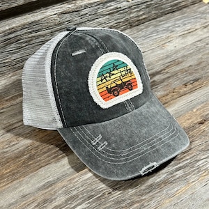 Könnte beinhalten: Eine schwarze und graue, abgenutzte Trucker-Kappe mit einem weißen Patch, der eine Grafik im Vintage-Stil mit einem Jeep-Silhouettenbild und dem Text "Jeep Life" zeigt.