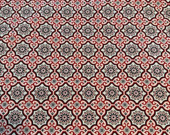 May include: A repeating pattern of black, red, and cream-colored floral and geometric shapes. The design features a symmetrical arrangement of stylized flowers and ornate scrollwork, creating a visually rich and detailed textile pattern.