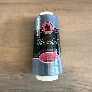 May include: A spool of blue Maxi-Lock all-purpose spun polyester thread. The label features the Singer logo and the words "Maxi-Lock" and "Thread". The spool has a white base and top.