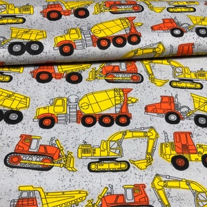 May include: A gray fabric with a repeating pattern of yellow and orange construction vehicles. The vehicles include dump trucks, excavators, bulldozers, and cement mixers.