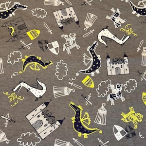 May include: Gray fabric with a repeating pattern of dragons, castles, shields, swords, and knights in white, yellow, and navy blue. The design has a whimsical, medieval theme.