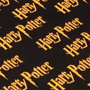 May include: Black fabric with a repeating pattern of the words "Harry Potter" in yellow.