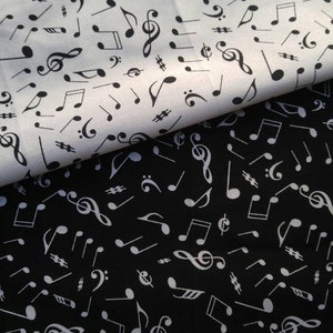 May include: Two fabric swatches, one white and one black, are covered in a repeating pattern of musical notes, including treble clefs, eighth notes, and sharps. The black fabric has white notes, while the white fabric has black notes.