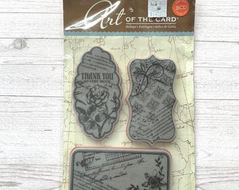 May include: A package of Hero Arts rubber stamps. The stamps are gray and feature floral and script designs. The package includes three stamps with the text "Art of the Card" and "Thank You So Very Much".