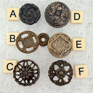 May include: A white ceramic mug with a black handle and the text "But First, Coffee" in a black, handwritten-style font. The mug is on a white surface.