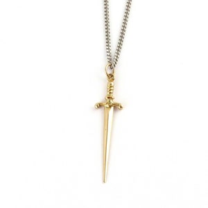 Peut inclure: Un collier avec un pendentif en forme de dague dor&eacute;e et une cha&icirc;ne en argent.