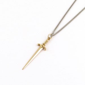 Peut inclure: Un collier avec un pendentif en forme de dague dor&eacute;e et une cha&icirc;ne en argent.