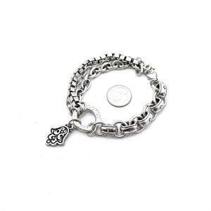 May include: Silver-toned bracelet featuring a layered design with a square chain and a larger link chain. A small Hamsa hand charm hangs from the bracelet. A US quarter is included for size reference. The bracelet is on a white background.