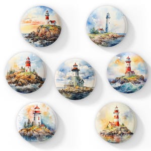 May include: Seven round buttons featuring watercolor paintings of lighthouses. Each button showcases a different lighthouse design, set against a backdrop of ocean, sky, and rocky terrain. The lighthouses vary in color and style, with red and white striped towers.