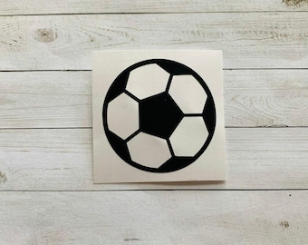 May include: A black and white soccer ball sticker. The soccer ball design features a classic pentagon and hexagon pattern. The sticker is on a white background.