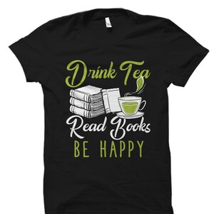 May include: Black t-shirt with a green graphic design that says "Drink Tea Read Books Be Happy". The graphic includes a stack of books, a cup of tea, and a tea leaf.