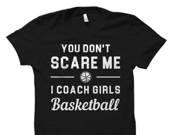 May include: Black t-shirt with white text that reads "You don't scare me I coach girls basketball" and a basketball graphic.