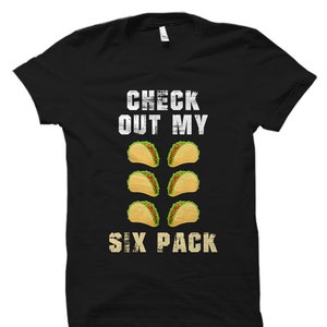 May include: Black t-shirt with white text that reads "Check out my six pack" and a graphic of six tacos.