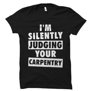 May include: Black t-shirt with white text that reads "I'm silently judging your carpentry."