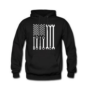 May include: Black hooded sweatshirt with a white design of a US flag made of wrenches and nuts.