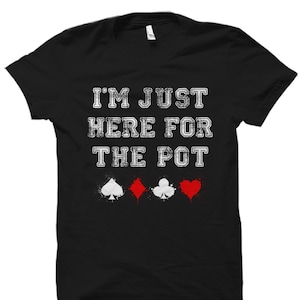 May include: Black t-shirt with white text that reads "I'm just here for the pot" and four playing card suit symbols below the text. The symbols are a spade, diamond, club, and heart.