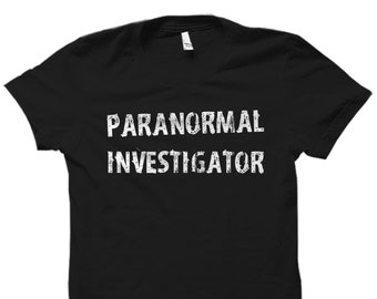 以下が含まれることがあります： 白い文字で「Paranormal Investigator」と書かれた黒いTシャツです。