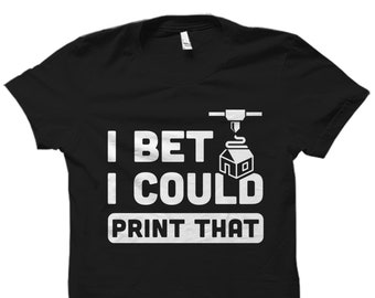 Puede incluir: Camiseta negra con texto blanco que dice "I bet I could print that" y un gráfico de una impresora 3D imprimiendo una casa.