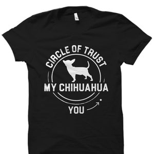 May include: Black t-shirt with a white circle graphic that says "Circle of Trust My Chihuahua You" with a silhouette of a chihuahua inside the circle.