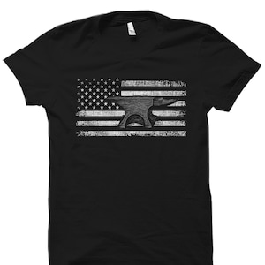 May include: Black t-shirt with a white distressed American flag design featuring an anvil in the center.