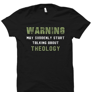 K&ouml;nnte beinhalten: Schwarzes T-Shirt mit dem Text "WARNING MAY SUDDENLY START TALKING ABOUT THEOLOGY" in Gr&uuml;n.