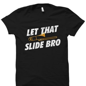 May include: Black t-shirt with white text that reads "Let That Slide Bro" and a gold trombone graphic.