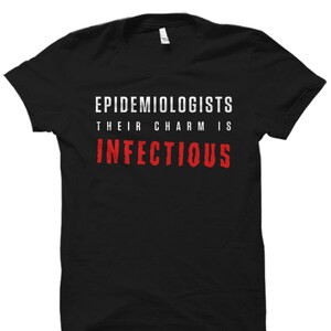 May include: Black t-shirt with white text that reads "Epidemiologists Their Charm Is Infectious" in red.