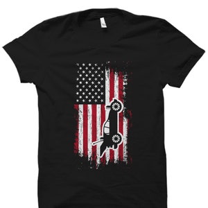 May include: Black t-shirt with a distressed American flag design and a silhouette of a car in front of it.