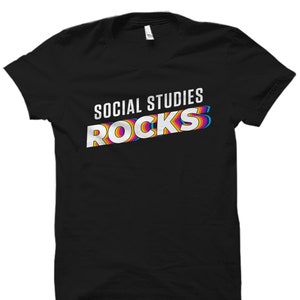 May include: Black t-shirt with the text "SOCIAL STUDIES ROCKS" in white with rainbow colored outlines.