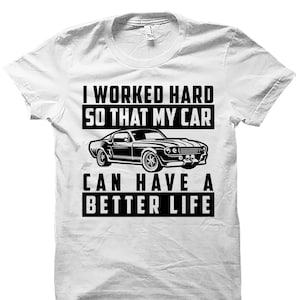 May include: White t-shirt with a black graphic of a classic car and the text "I worked hard so that my car can have a better life."