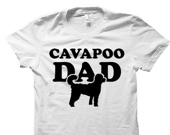 May include: White t-shirt with black text that reads "Cavapoo Dad" and a black silhouette of a Cavapoo dog.