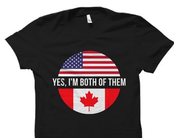 May include: Black t-shirt with a circle graphic featuring the American and Canadian flags. The text "YES, I'M BOTH OF THEM" is printed below the graphic.