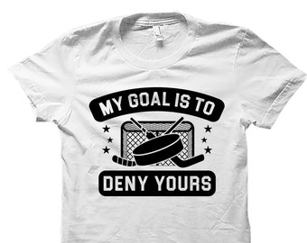 May include: White t-shirt with a black graphic that says "My goal is to deny yours" with a hockey net and puck.